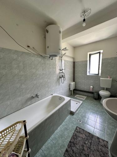 a bathroom with a tub and a toilet and a sink at Hostel in Valbonë