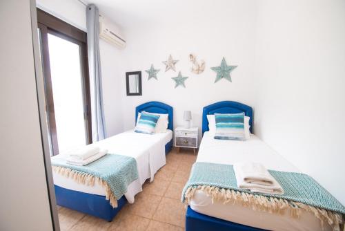 2 camas en una habitación con estrellas en la pared en The Olive Garden-Almyrida, en Almyrida
