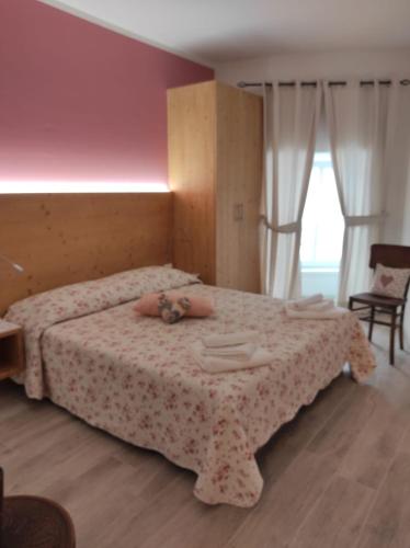 een slaapkamer met een bed waar een persoon op ligt bij Appartamenti l'Antica Corte in Levico Terme