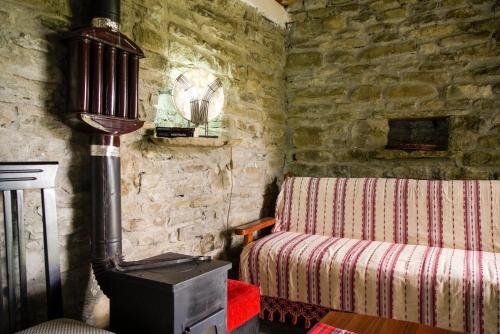 a corner of a room with a bed and a stove at Ferma Albanik in Këlcyrë