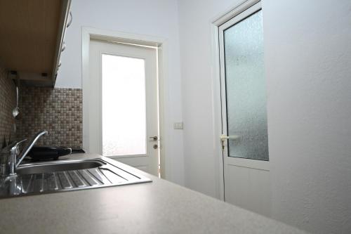 a kitchen with a sink and a window at Lakeside Serenity - DESARET in Pogradec