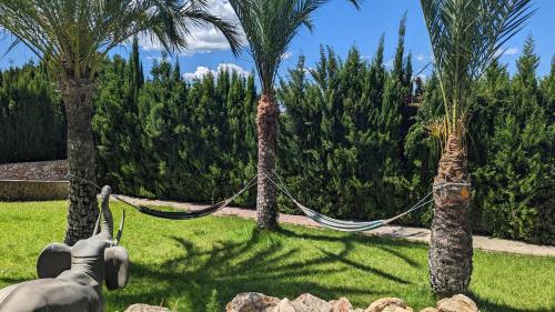 a statue of an elephant chained to two palm trees at El Collado in Cullera