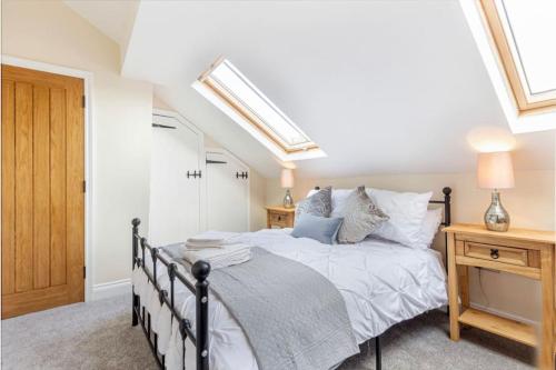a bedroom with a bed and a skylight at Cosy 2 bed with parking and garden in Cawston
