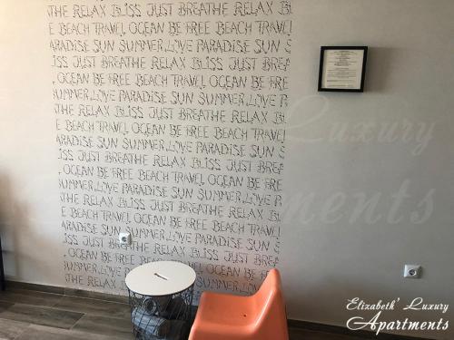 a wall with writing on it with a table and a chair at Beachfront Luxury Apartments Elizabeth, Pomorie in Pomorie