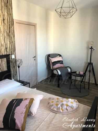 a bedroom with a bed and a chair and a table at Beachfront Luxury Apartments Elizabeth, Pomorie in Pomorie