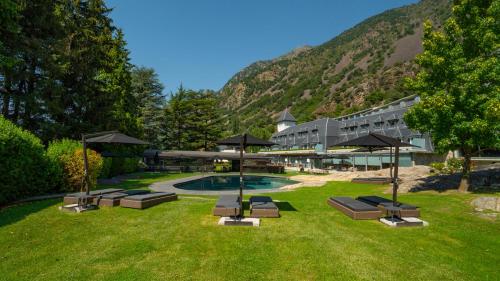 a resort with a pool with chairs and umbrellas at Andorra Park Hotel in Andorra la Vella