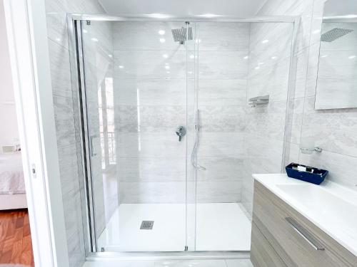 um banheiro branco com chuveiro e pia em La Canzonetta Affittacamere em Nápoles