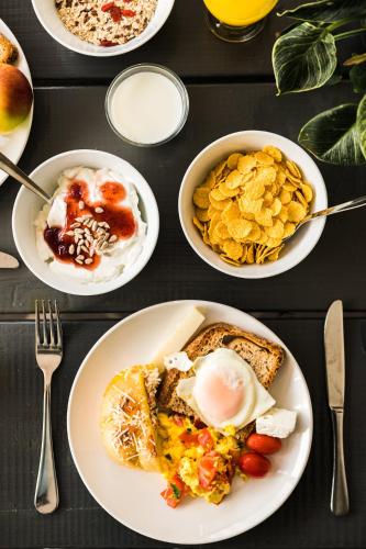a table topped with plates of breakfast food with eggs at Gefiri Plakas Hotel, Tzoumerka in Plaka