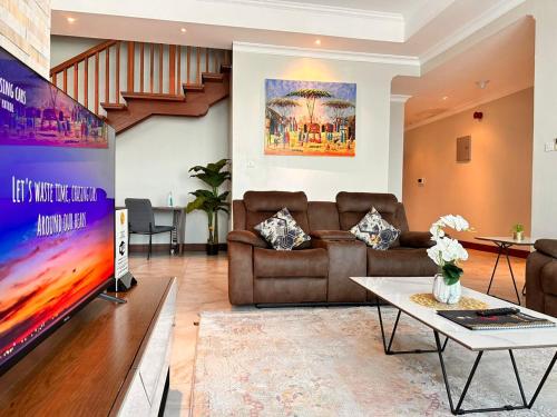 a living room with a couch and a tv at Fairview Luxury Apartments in Dar es Salaam