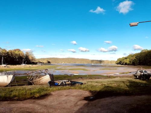 a group of boats sitting on the shore of a river at Relaxing Riverside Cottage in Llangwm