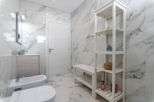 La salle de bains blanche est pourvue de toilettes et d'un lavabo. dans l'établissement Iate Residence, à Portimão