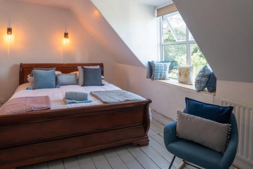 1 dormitorio con 1 cama y 1 silla azul en Belmont Villa, en Ilfracombe