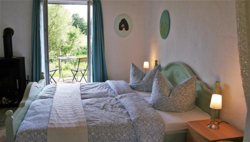 una camera da letto con letto, cuscini e finestra di Apartment im ART.Quartier a Velgast