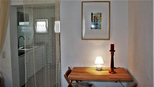 a room with a table and a candle and a glass shower at Apartment im ART.Quartier in Velgast