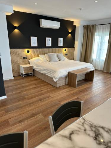 a bedroom with a large bed and wooden floors at First Flatotel International in Benalmádena