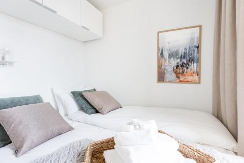 a living room with two white beds and a picture at Arctic Taiga Penthouse City Suite in Rovaniemi