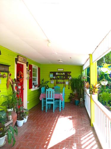 een groen huis met een tafel en stoelen op een patio bij Madie's Place Guest House in Santa Rosa