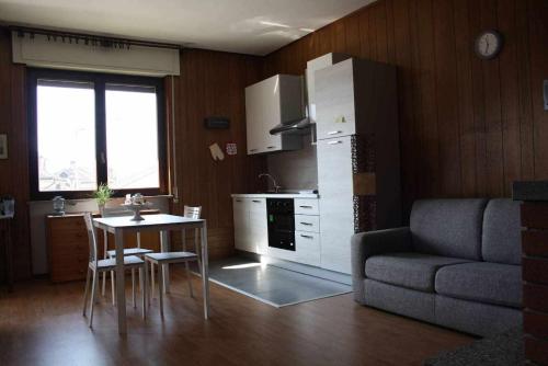 a kitchen with a table and a couch and a table and a kitchen with at Bluelake Apartament 1 Omegna in Omegna