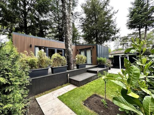 a garden with benches and plants in a house at FIKA Luxe vakantiewoning voor 4 personen @ Veluwe in Hoenderloo
