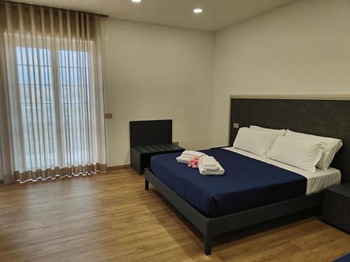 una camera da letto con un letto e due asciugamani di Rosa Rooms Pompei a Pompei