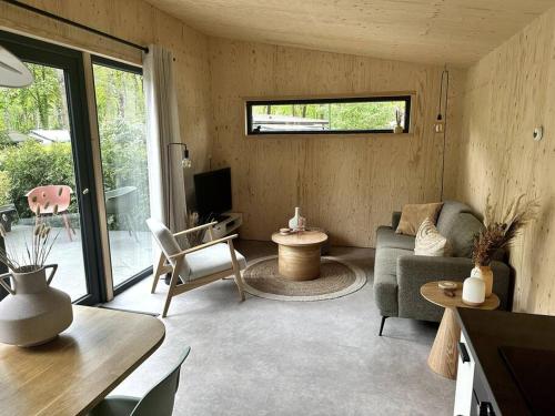 a living room with a couch and a tv at FIKA Luxe vakantiewoning voor 4 personen @ Veluwe in Hoenderloo