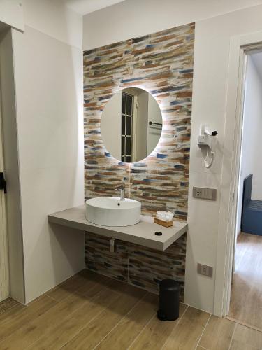 un bagno con lavandino e specchio di Rosa Rooms Pompei a Pompei