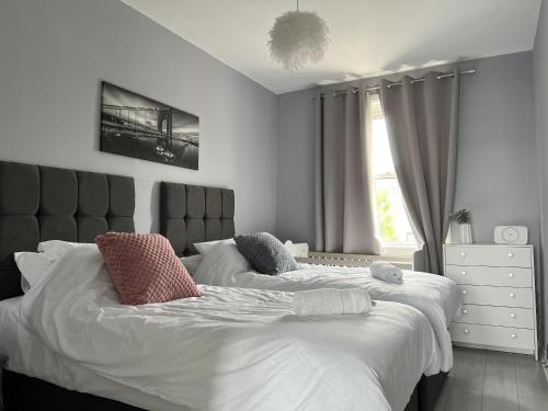 a bedroom with two beds and a window at Captivating 2-Bed Apartment in Kirkcaldy in Kirkcaldy