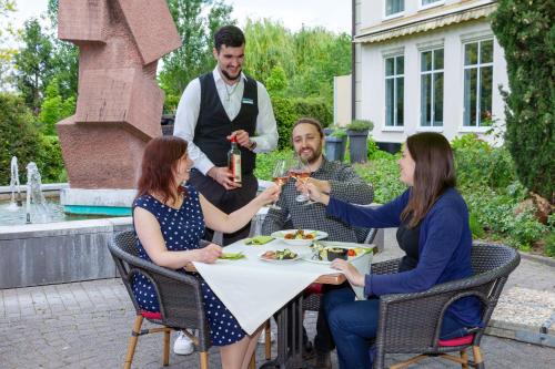 a group of people sitting around a table eating food at Best Western Wein- und Parkhotel in Nierstein