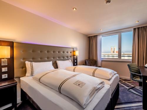 2 letti in una camera d'albergo con finestra di Premier Inn München City Zentrum a Monaco