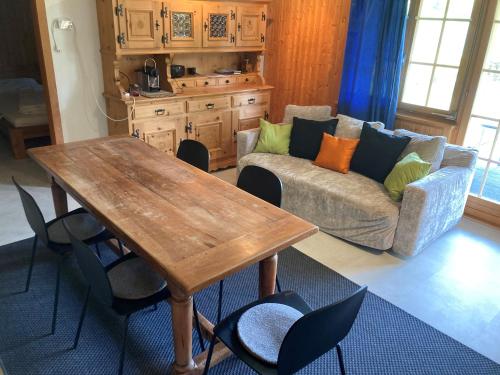 sala de estar con mesa de madera y sofá en Chalet Hagenbächli, en Schwarzsee