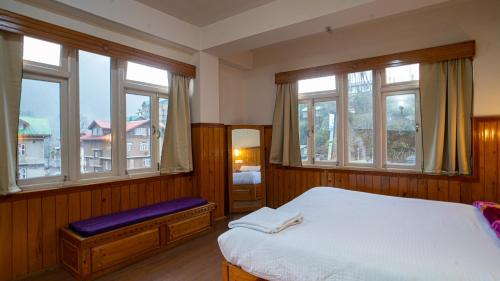 a bedroom with a bed and some windows at KhenKhim Regency, Lachen all meals included in Lachen