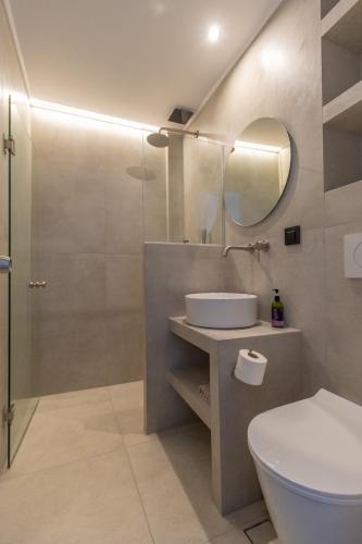 a bathroom with a toilet and a sink and a mirror at Artina in Marathopolis