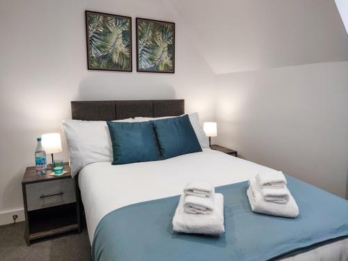 een slaapkamer met een groot bed en handdoeken bij City Centre Premier Top Floor Executive 2 Bed Apartment in Sunderland