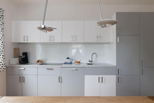una cocina blanca con armarios blancos y fregadero en Spacious, quiet 4 room flat en Salzburgo
