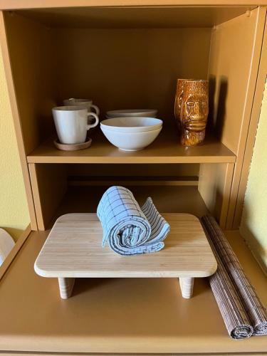 una estantería de madera con tazones y una toalla. en Costal apartment en Glyfada