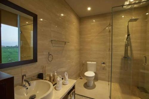 ein Bad mit einem WC, einem Waschbecken und einer Dusche in der Unterkunft Araya Luxe Villa in Munggu