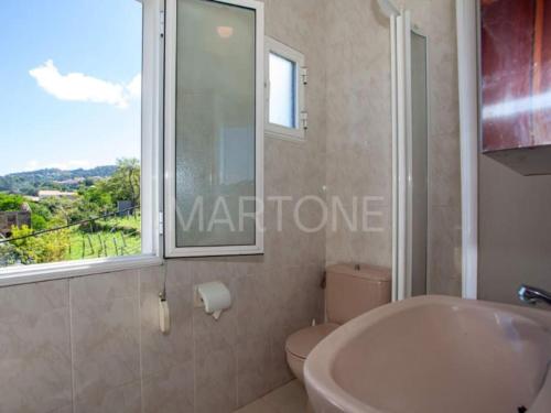 a bathroom with a sink and a toilet and a window at Casa Vacacional Vigo Planta Alta in Vigo