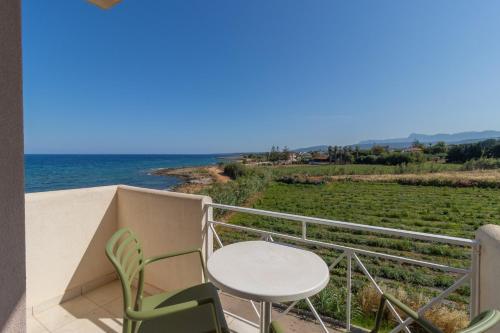 a balcony with a table and chairs and the ocean at Artina in Marathopolis