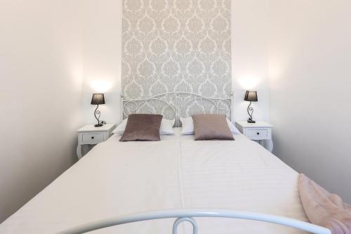 a bedroom with a large white bed with two lamps at APARTMAN BORGO MARINA - by the sea in Rijeka