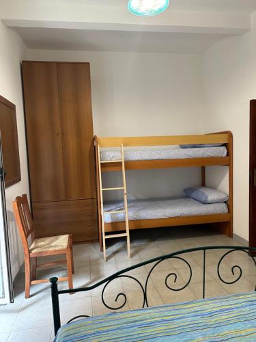 a bedroom with two bunk beds and a chair at Stefano apartment 2km Tropea boat cruise included in Parghelia