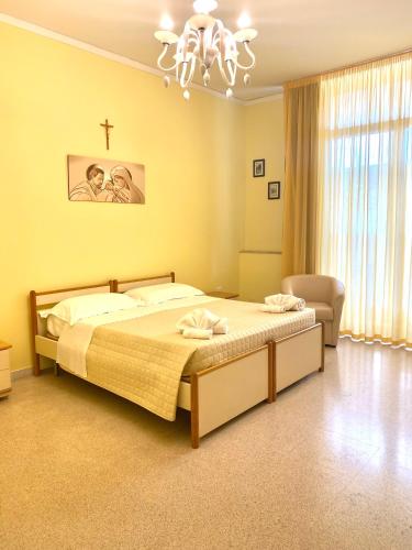 1 dormitorio con 1 cama y 1 cruz en la pared en OSTELLO MADRE SANTINA, en Lecce
