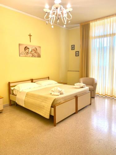 a bedroom with a bed and a cross on the wall at OSTELLO MADRE SANTINA in Lecce