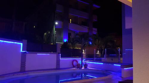 a building with a swimming pool at night with blue lights at The Monalysa Suites & Residence in Grand Baie