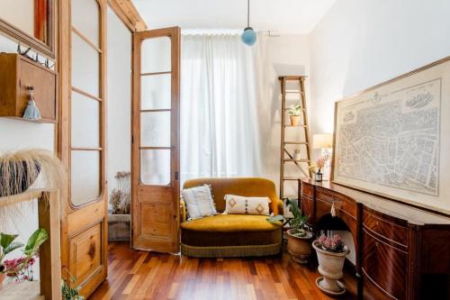 a living room with a chair and a large window at Habitación en La Rambla in Girona