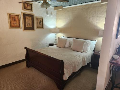 a bedroom with a bed with white sheets and pillows at Cleopatra Mountain Farmhouse in Fort Nottingham