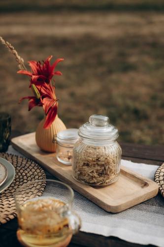 a table with two glass jars of seeds on a cutting board at Amberhouse Glempings in Piejūti