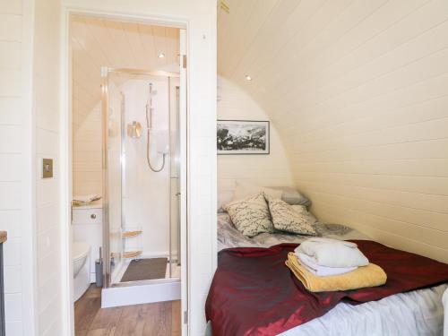 a small room with a bed and a bathroom at The South Lodge Retreat in East Grinstead