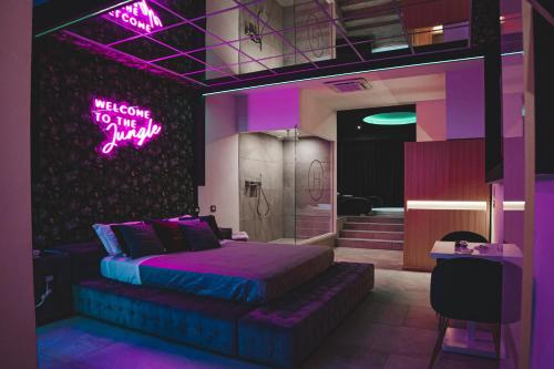 a bedroom with a bed and a neon sign on the wall at Capri Spa Hotel in Casoria