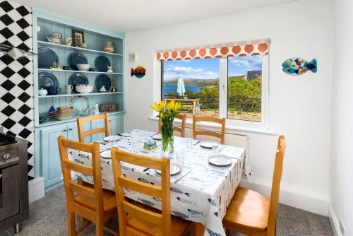 a dining room with a table and chairs and a window at Cottage 439 - Clifden in Clifden