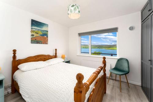 een slaapkamer met een bed, een raam en een stoel bij Cottage 439 - Clifden in Clifden